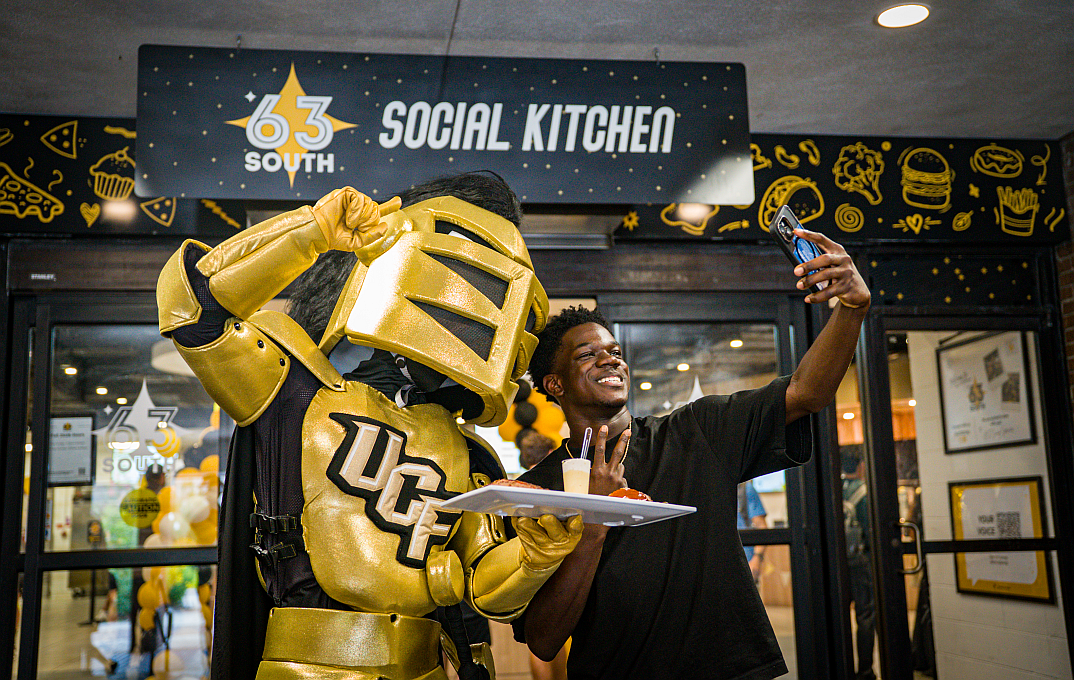 student taking a selfie with the school mascot